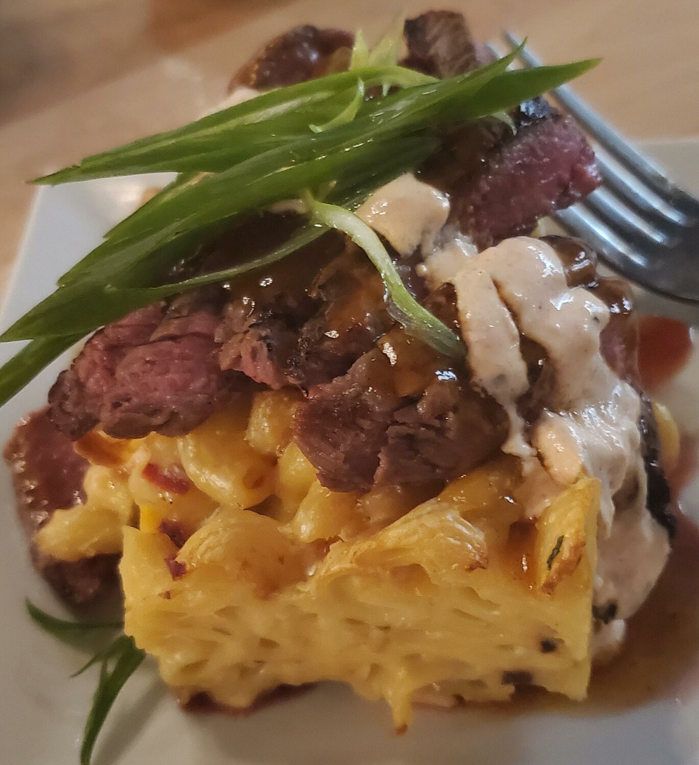 Ribeye Mac N Cheese — Baked cavatappi, smoked cheeses, red chili datil glaze, Spanish crème, charbroiled ribeye with bacon and peppers